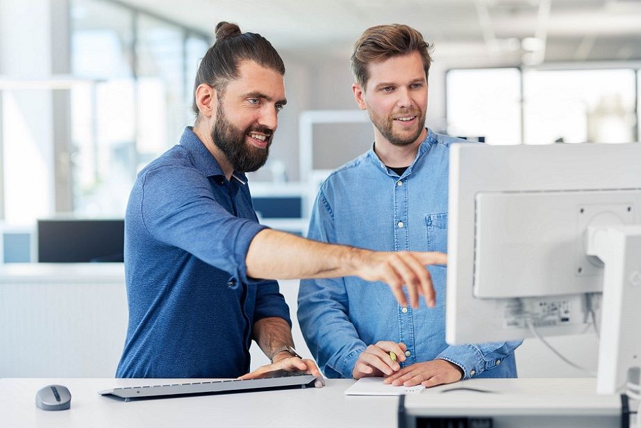 Zwei ITK-Mitarbeitende im Büro besprechen maßgeschneiderte Simulations-Lösungen am Computer.