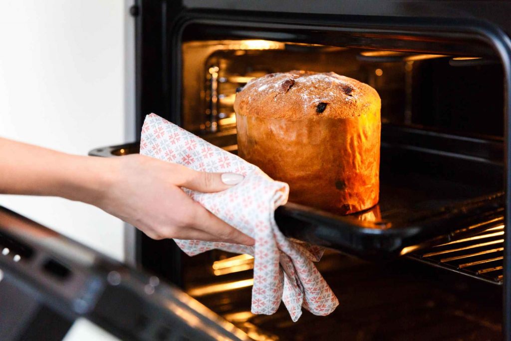 Ein Kuchen wird aus einem Smart Home Backofen mit KI von ITK für genauere Garzeitvoraussage geholt.